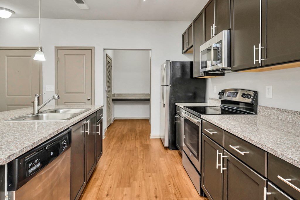 A kitchen with dark brown cabinets and stainless steel appliances.